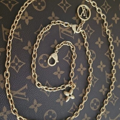 BANDOULIERE EN CHAINE DOREE LOUIS VUITTON 2 EN 1. CEINTURE REGLABLE EXTENSIBLE FLEUR MONOGRAMME. LUXE DE SECONDE MAIN AUTHENTIQUE.