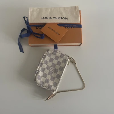 Louis Vuitton mini pochette accessoires damier azur. Photos des sacs de luxe authentiques de seconde main vendus par Les Trésors de Djen : sacs à main de grandes marques comme Louis Vuitton, Chanel, Dior, Gucci, Saint Laurent en excellent état, 100 % authentiques, à prix avantageux.