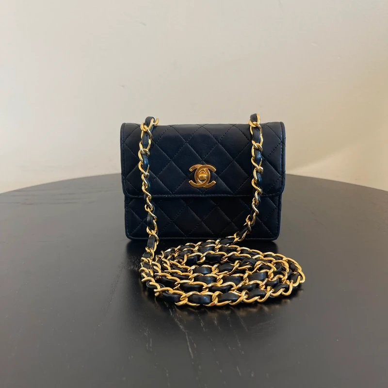 CHANEL mini flap bag en cuir d'agneau lisse noir & doré avec poinçon. SAC DE LUXE DE SECONDE MAIN AUTHENTIQUE CERTIFICAT D'AUTHENTICITE ENTRUPY. SAC DE LUXE D'OCCASION PAS CHER. Chanel timeless