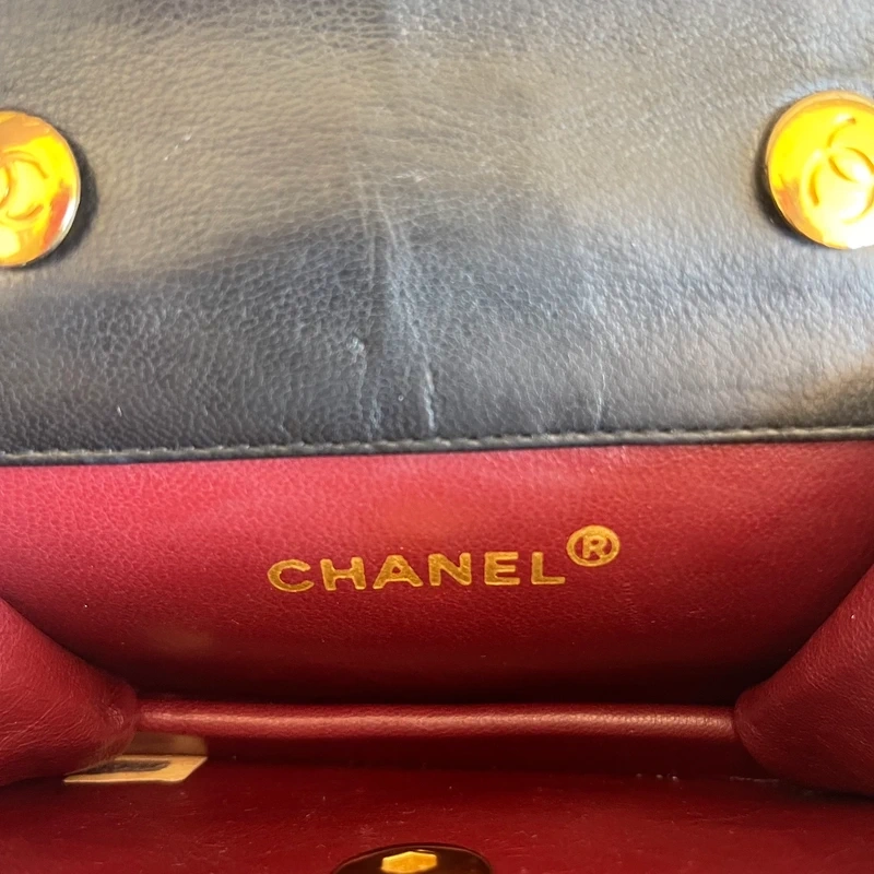 CHANEL mini flap bag en cuir d'agneau lisse noir & doré avec poinçon. SAC DE LUXE DE SECONDE MAIN AUTHENTIQUE CERTIFICAT D'AUTHENTICITE ENTRUPY. SAC DE LUXE D'OCCASION PAS CHER. Chanel timeless
