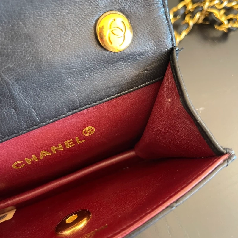 CHANEL mini flap bag en cuir d'agneau lisse noir & doré avec poinçon. SAC DE LUXE DE SECONDE MAIN AUTHENTIQUE CERTIFICAT D'AUTHENTICITE ENTRUPY. SAC DE LUXE D'OCCASION PAS CHER. Chanel timeless