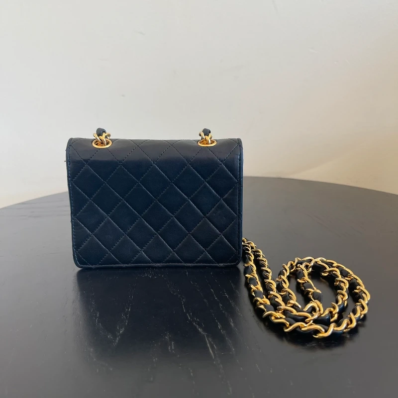 CHANEL mini flap bag en cuir d'agneau lisse noir & doré avec poinçon. SAC DE LUXE DE SECONDE MAIN AUTHENTIQUE CERTIFICAT D'AUTHENTICITE ENTRUPY. SAC DE LUXE D'OCCASION PAS CHER. Chanel timeless