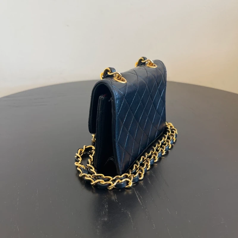 CHANEL mini flap bag en cuir d'agneau lisse noir & doré avec poinçon. SAC DE LUXE DE SECONDE MAIN AUTHENTIQUE CERTIFICAT D'AUTHENTICITE ENTRUPY. SAC DE LUXE D'OCCASION PAS CHER. Chanel timeless
