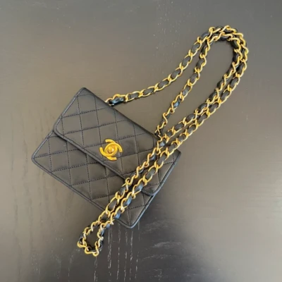 CHANEL mini flap bag en cuir d'agneau lisse noir & doré avec poinçon. SAC DE LUXE DE SECONDE MAIN AUTHENTIQUE CERTIFICAT D'AUTHENTICITE ENTRUPY. SAC DE LUXE D'OCCASION PAS CHER. Chanel timeless