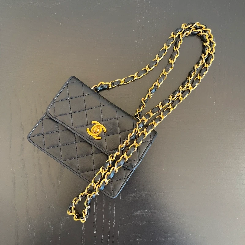 CHANEL mini flap bag en cuir d'agneau lisse noir & doré avec poinçon. SAC DE LUXE DE SECONDE MAIN AUTHENTIQUE CERTIFICAT D'AUTHENTICITE ENTRUPY. SAC DE LUXE D'OCCASION PAS CHER. Chanel timeless