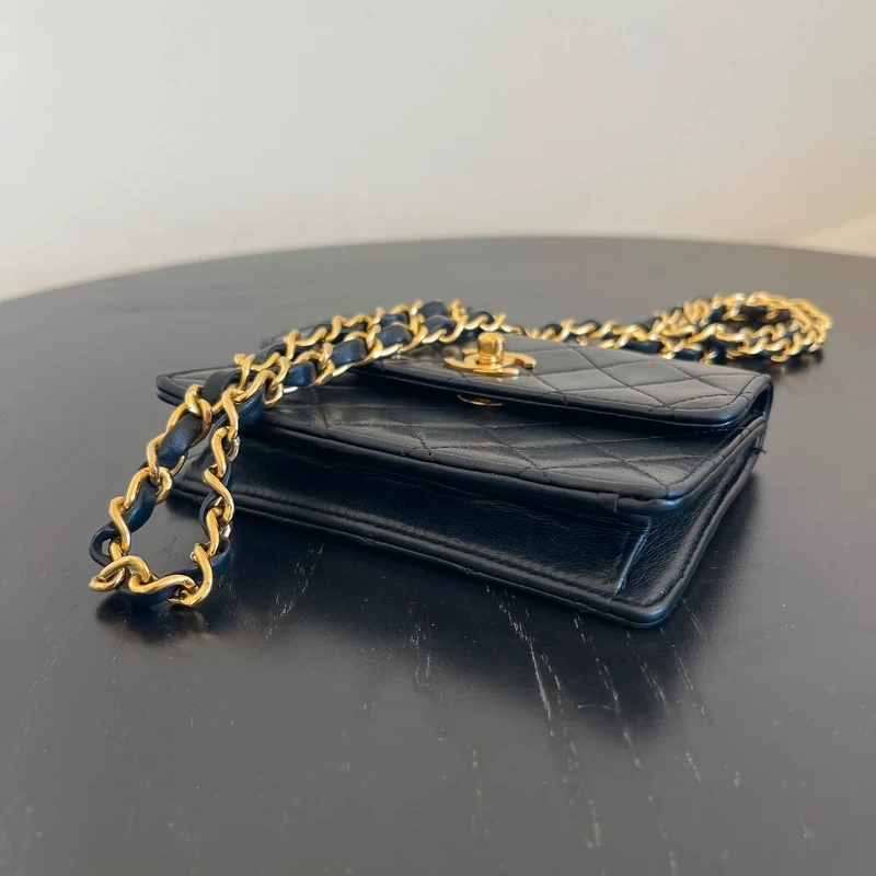 CHANEL mini flap bag en cuir d'agneau lisse noir & doré avec poinçon. SAC DE LUXE DE SECONDE MAIN AUTHENTIQUE CERTIFICAT D'AUTHENTICITE ENTRUPY. SAC DE LUXE D'OCCASION PAS CHER. Chanel timeless